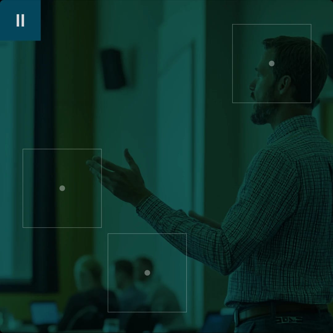 A man giving a presentation in a classroom or conference room.