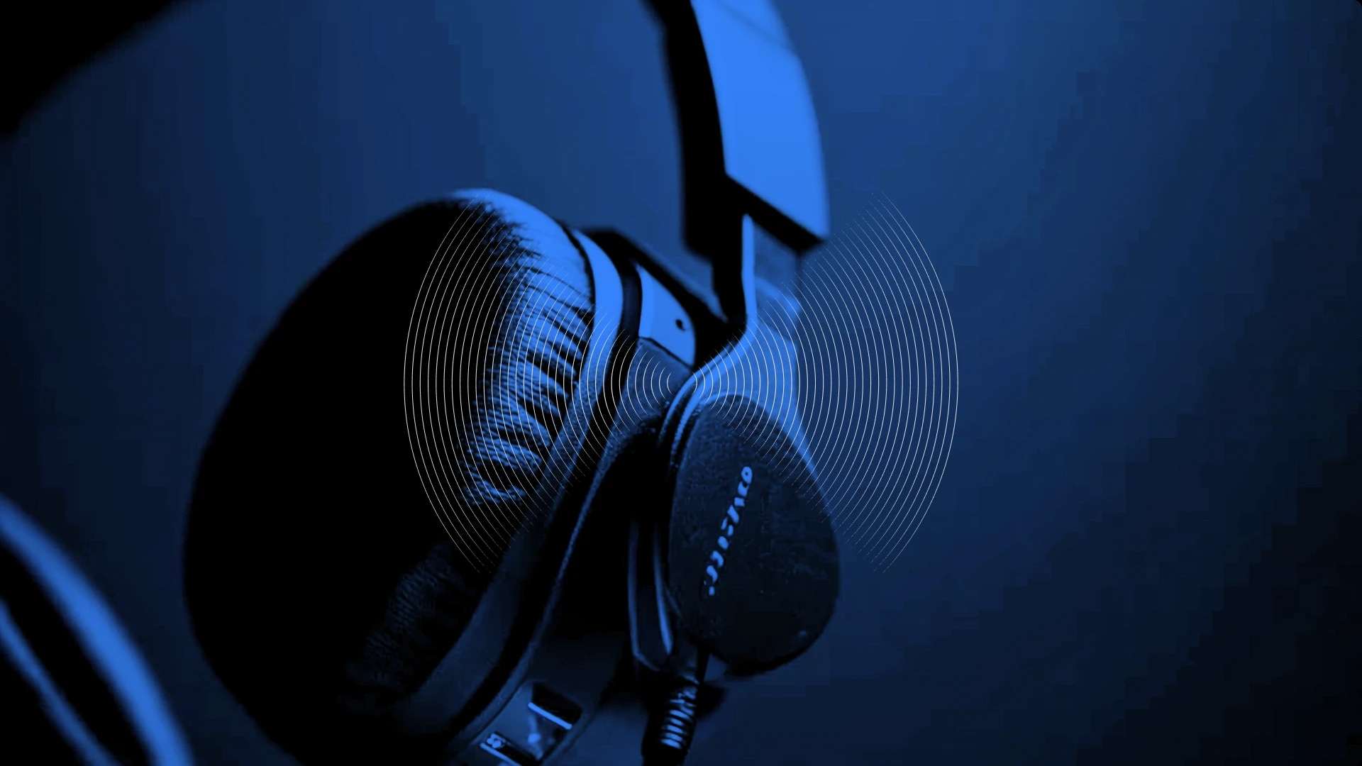 Over-ear headphones with a blue lighting effect and sound wave graphic.