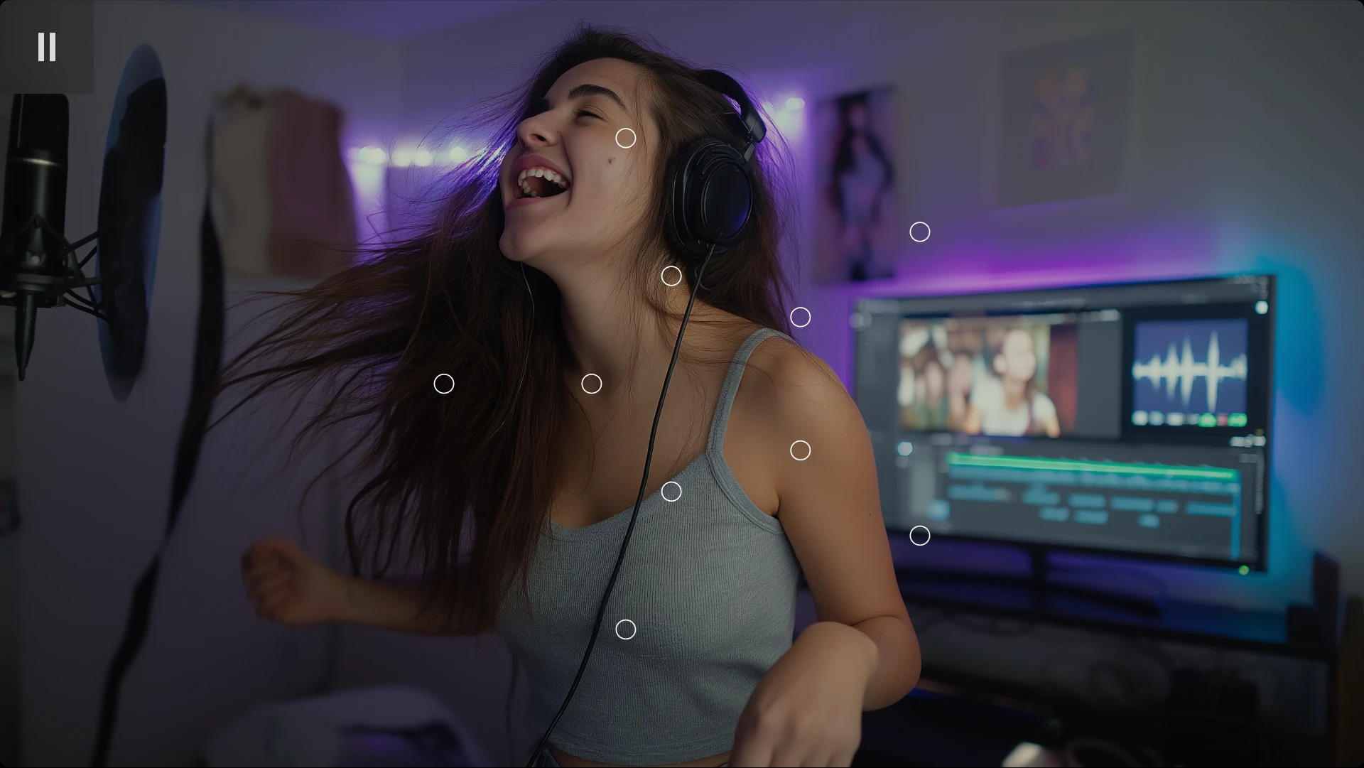 Young woman with long hair singing or speaking into a microphone while wearing headphones in a home studio.