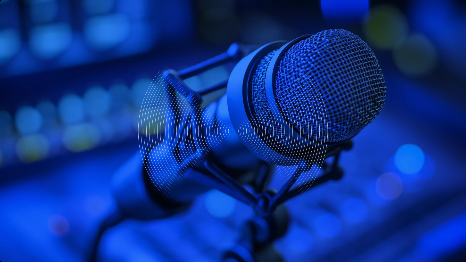 A professional microphone with a pop filter in a recording studio, illuminated by blue lighting.