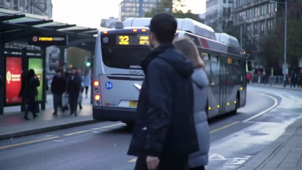 A person walking on a city street near a bus stop with a bus in the background.