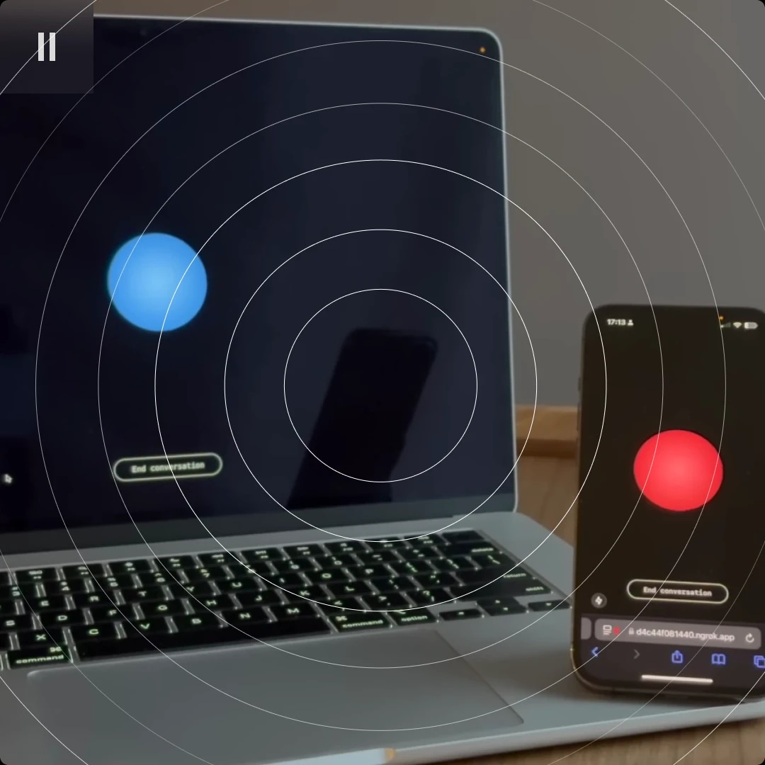 A laptop and a smartphone both displaying an incoming call screen with "End conversation" options, on a wooden surface.