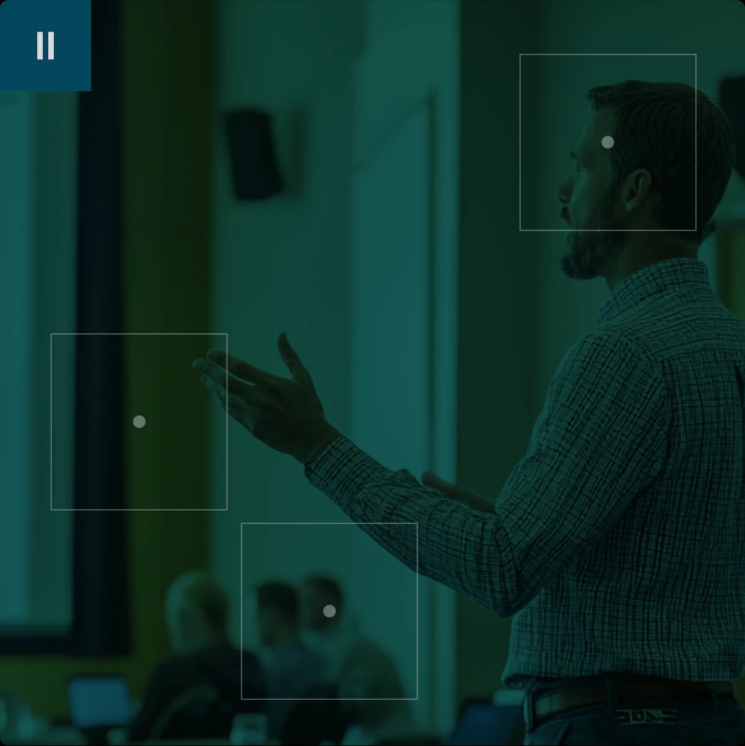 A man giving a presentation in a classroom or conference room.