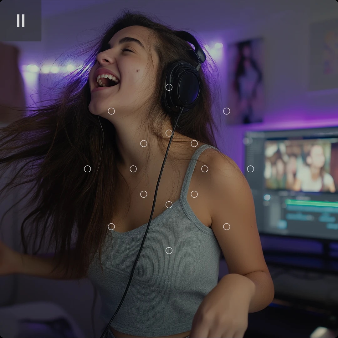 A young woman with long hair wearing headphones, smiling and enjoying music or a video in a room with purple lighting.