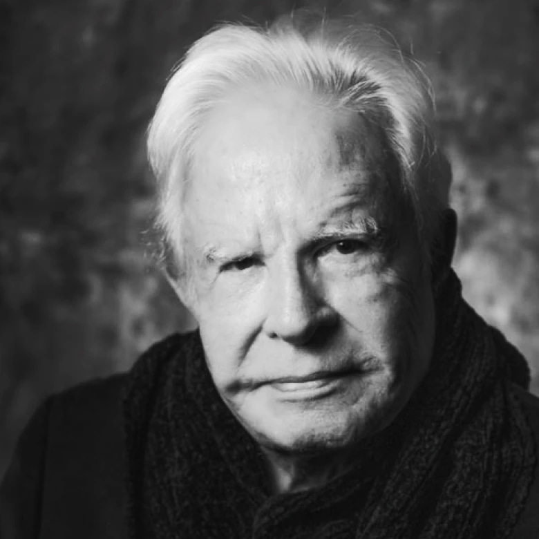 Black and white portrait of an elderly man with white hair, wearing a dark scarf.