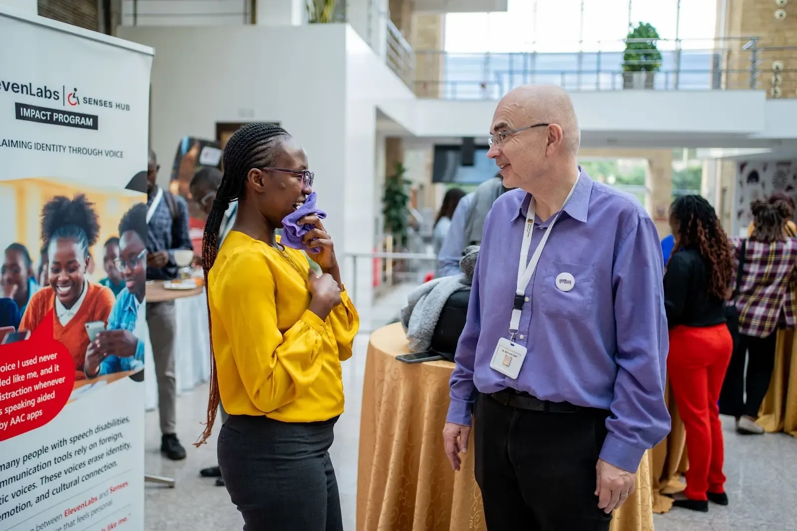 A woman and man smiling at each other at a conference